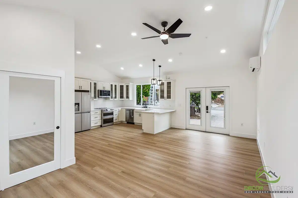 Home renovation featuring an open-concept living and kitchen area with white walls, hardwood flooring, ceiling fan, and recessed lighting in Morgan Hill, CA