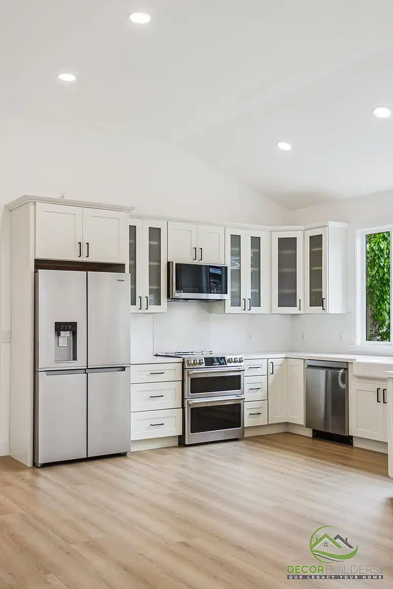 Custom kitchen remodel showcasing white cabinetry, stainless steel refrigerator, double oven, microwave, and hardwood flooring in Morgan Hill, CA