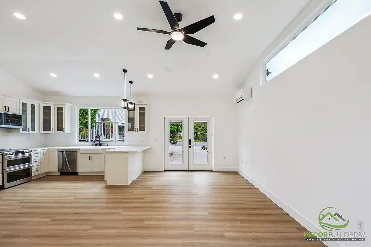 Home renovation featuring an open-concept kitchen and living area with white cabinetry, hardwood flooring, and ceiling fan in Morgan Hill, CA