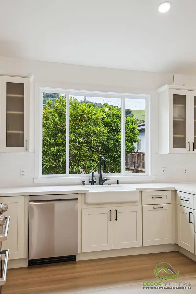 Kitchen renovation featuring white upper cabinetry, dark lower cabinets, stainless steel dishwasher, undermount sink, and large window in Morgan Hill, CA
