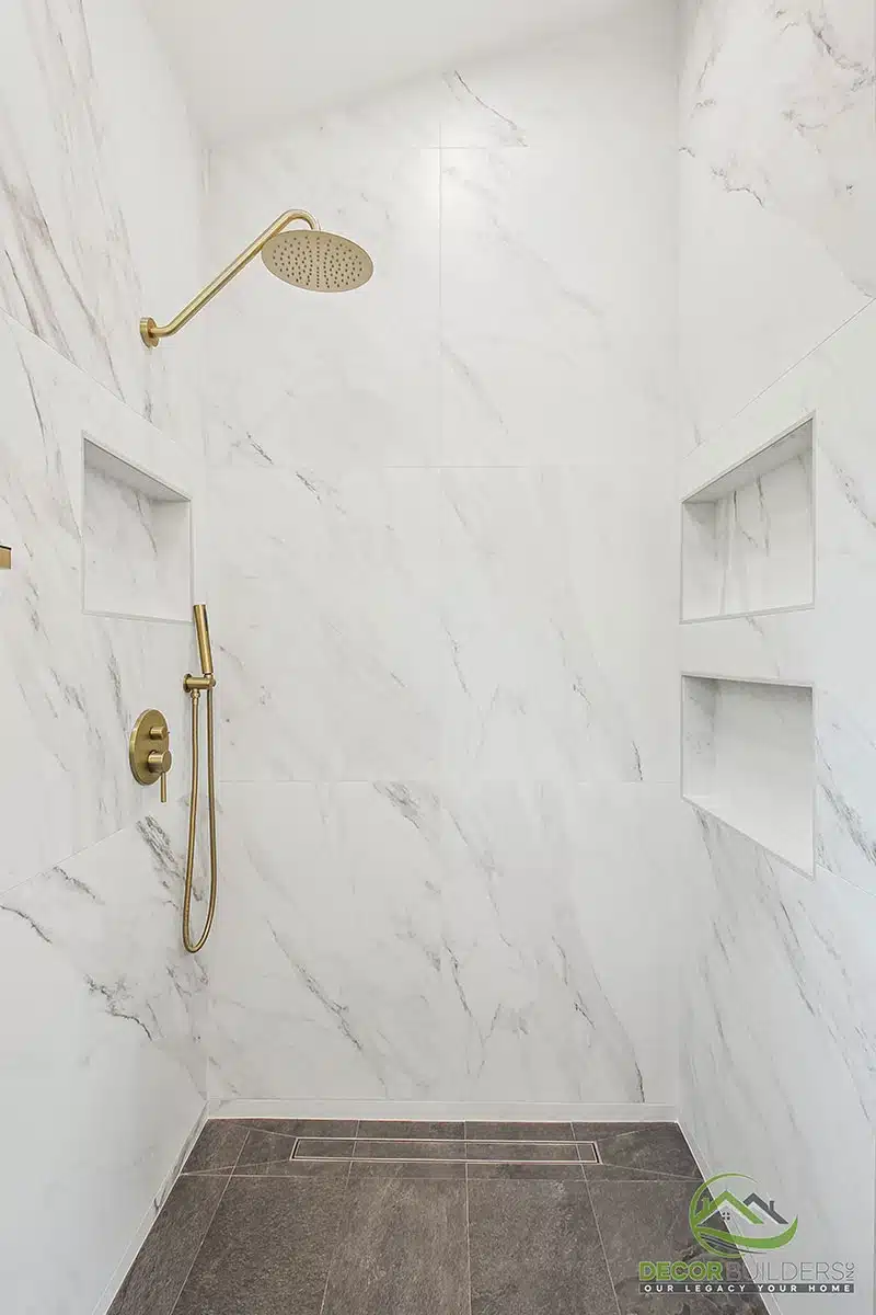 Luxury bathroom renovation featuring a walk-in marble tile shower with gold rainfall showerhead and built-in niche in Morgan Hill, CA