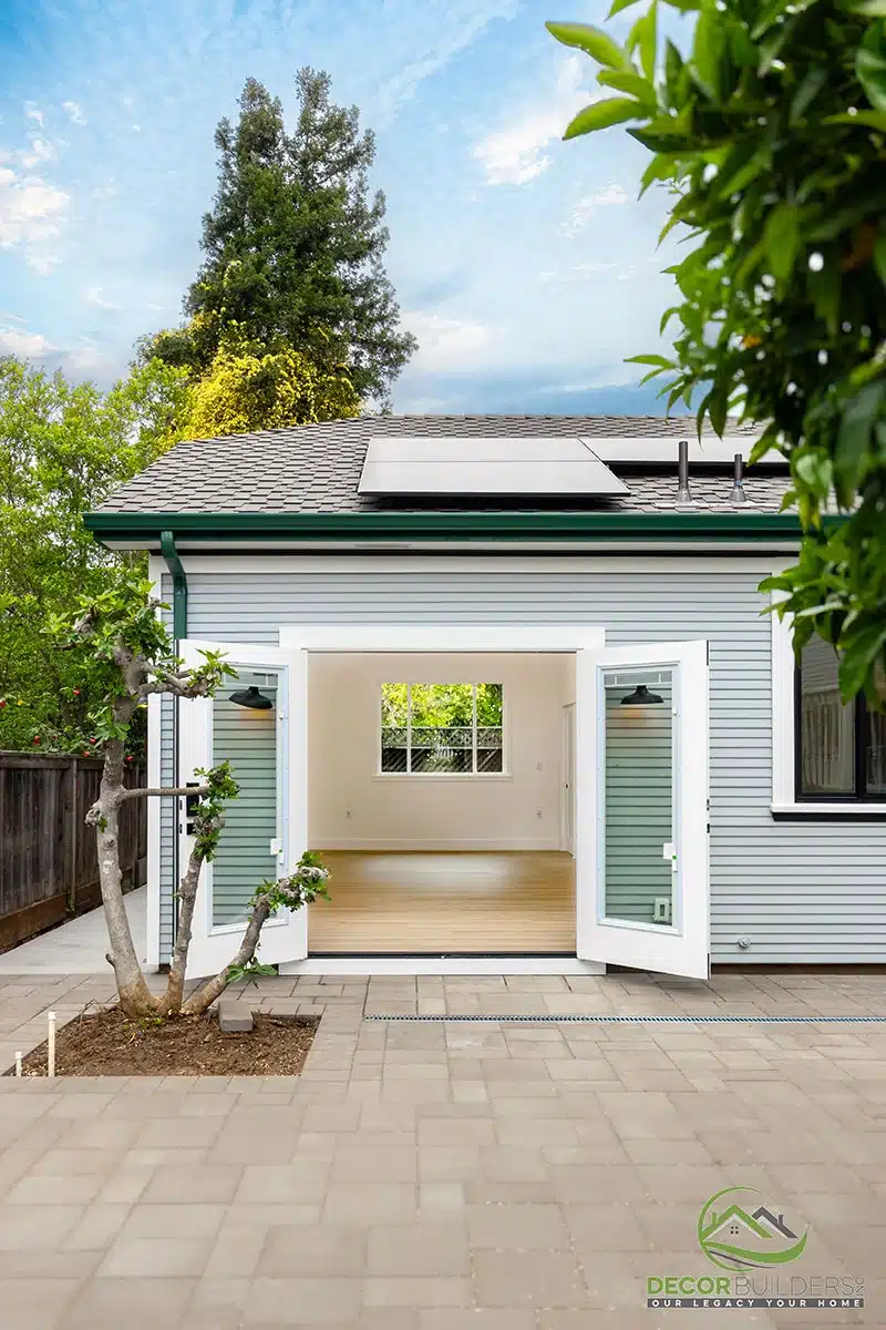 Custom ADU builders showcasing a white exterior with French doors, concrete pathway, and mature trees in Morgan Hill, CA