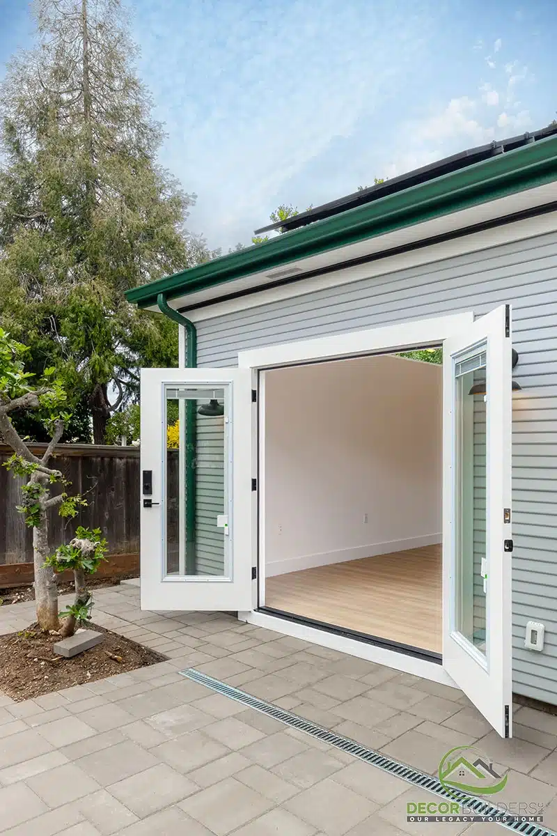 Custom ADU construction featuring an open French door entry, white exterior, and lush landscaping in Morgan Hill, CA