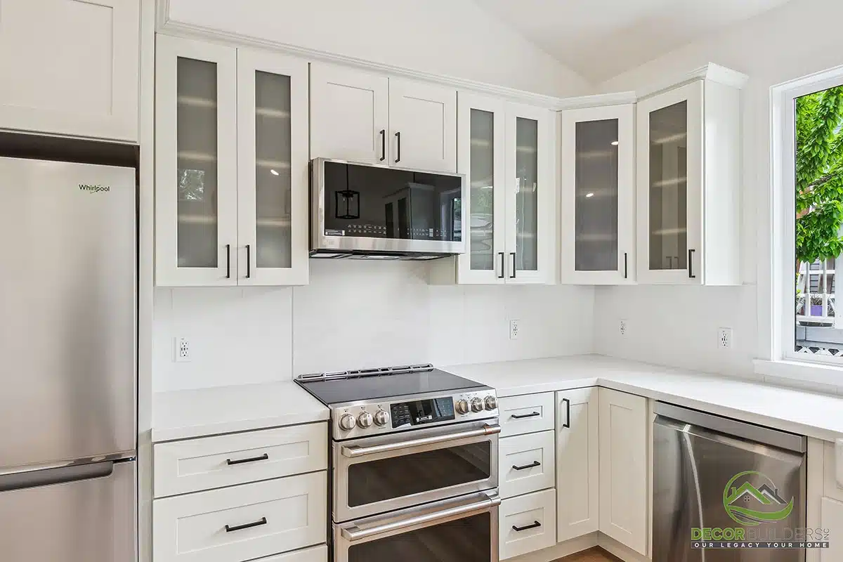 Kitchen renovation with white glass-front upper cabinets, stainless steel appliances, white countertops, and hardwood flooring in Morgan Hill, CA