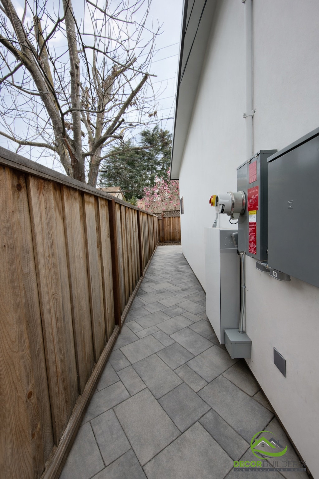 ADU builders side yard with stone paver path, wood privacy fence, and utility panel, Sunnyvale CA