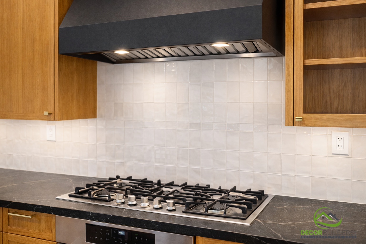 Kitchen renovation featuring warm wood cabinetry and a gas cooktop with a dark soapstone countertop and white subway tile backsplash in Palo Alto