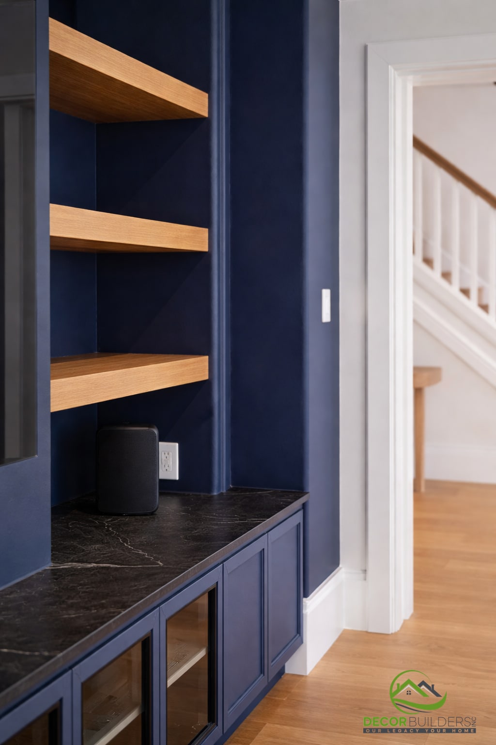 Custom built-in navy blue shelving unit with warm wood shelf accents and dark stone countertop detail in Palo Alto