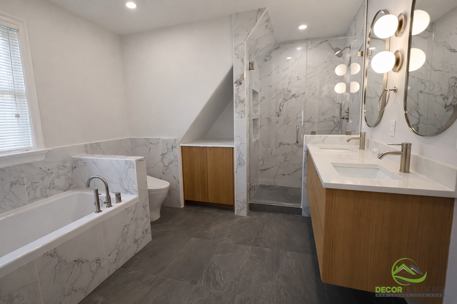 Bathroom renovation showcasing a freestanding soaking tub, wood vanity, and white marble tile walls with a skylight in Palo Alto