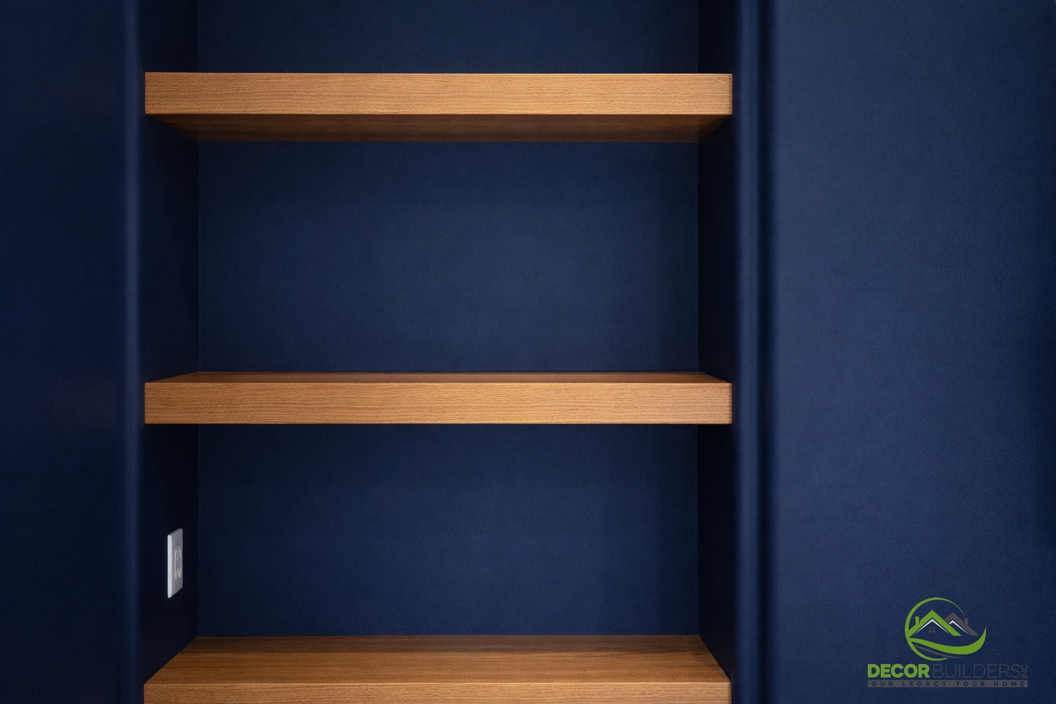 Navy blue built-in shelving with open wood shelves and dark base cabinetry as part of a custom home remodel in Palo Alto