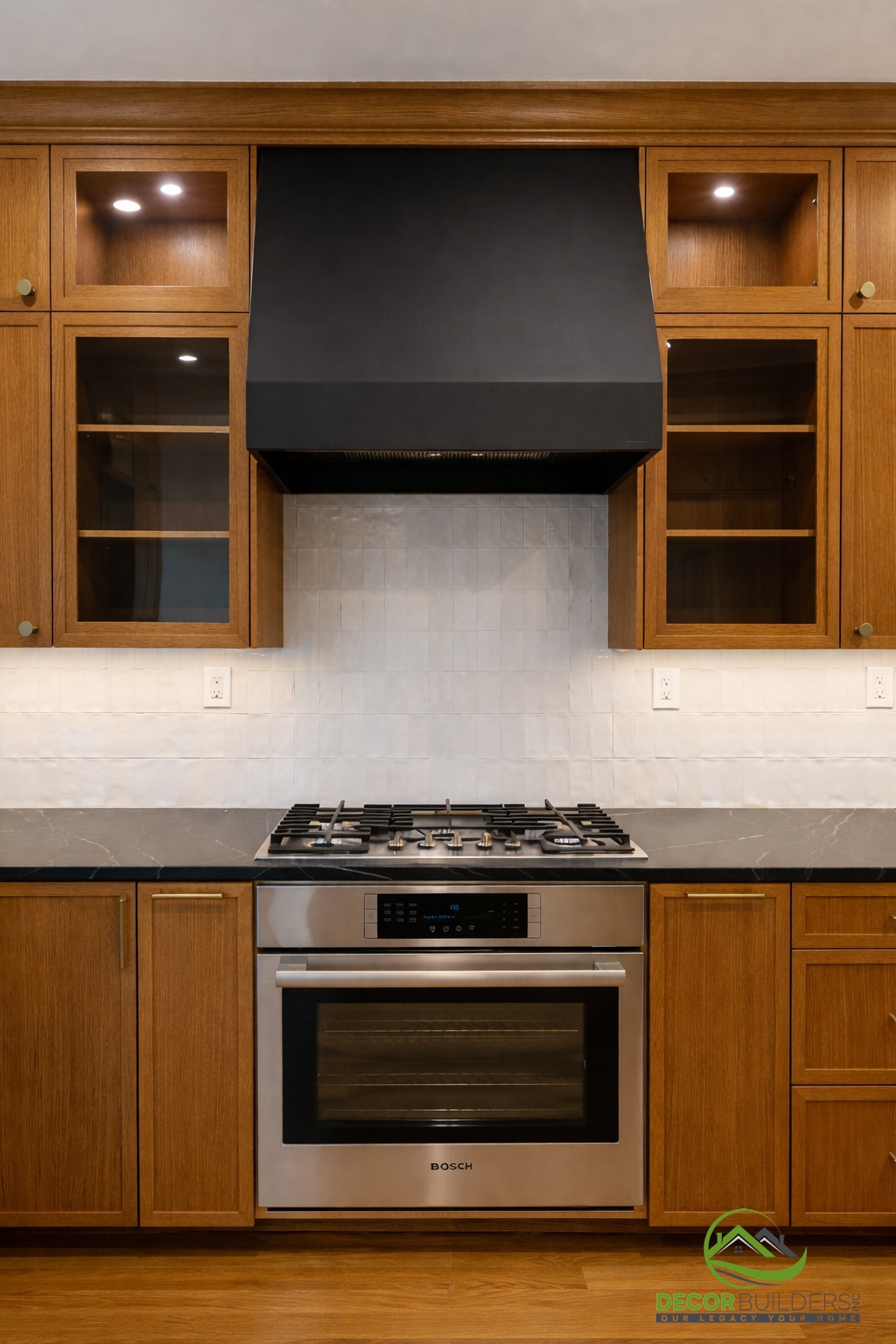 Kitchen remodel showcasing wood cabinetry with glass-front upper cabinets, black range hood, and stainless steel gas cooktop in Palo Alto
