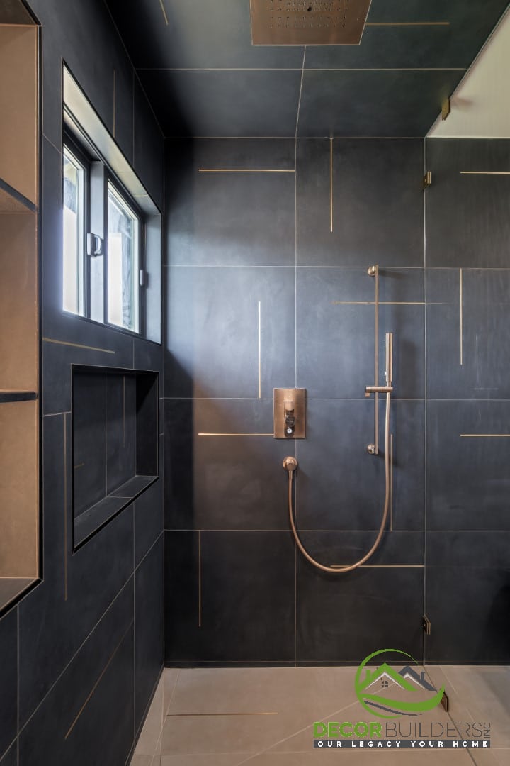 Close-up of brass shower fixtures against dark tile, a bathroom remodeling detail in Campbell, CA
