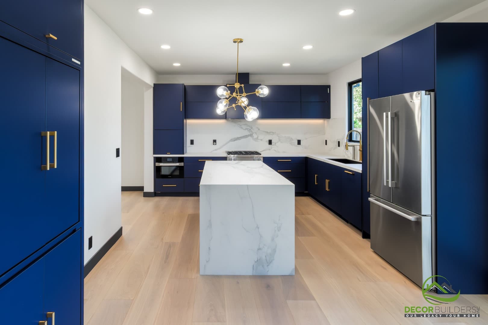 Navy blue kitchen with marble-look island and stainless steel appliances, completed during custom home construction in Campbell, CA