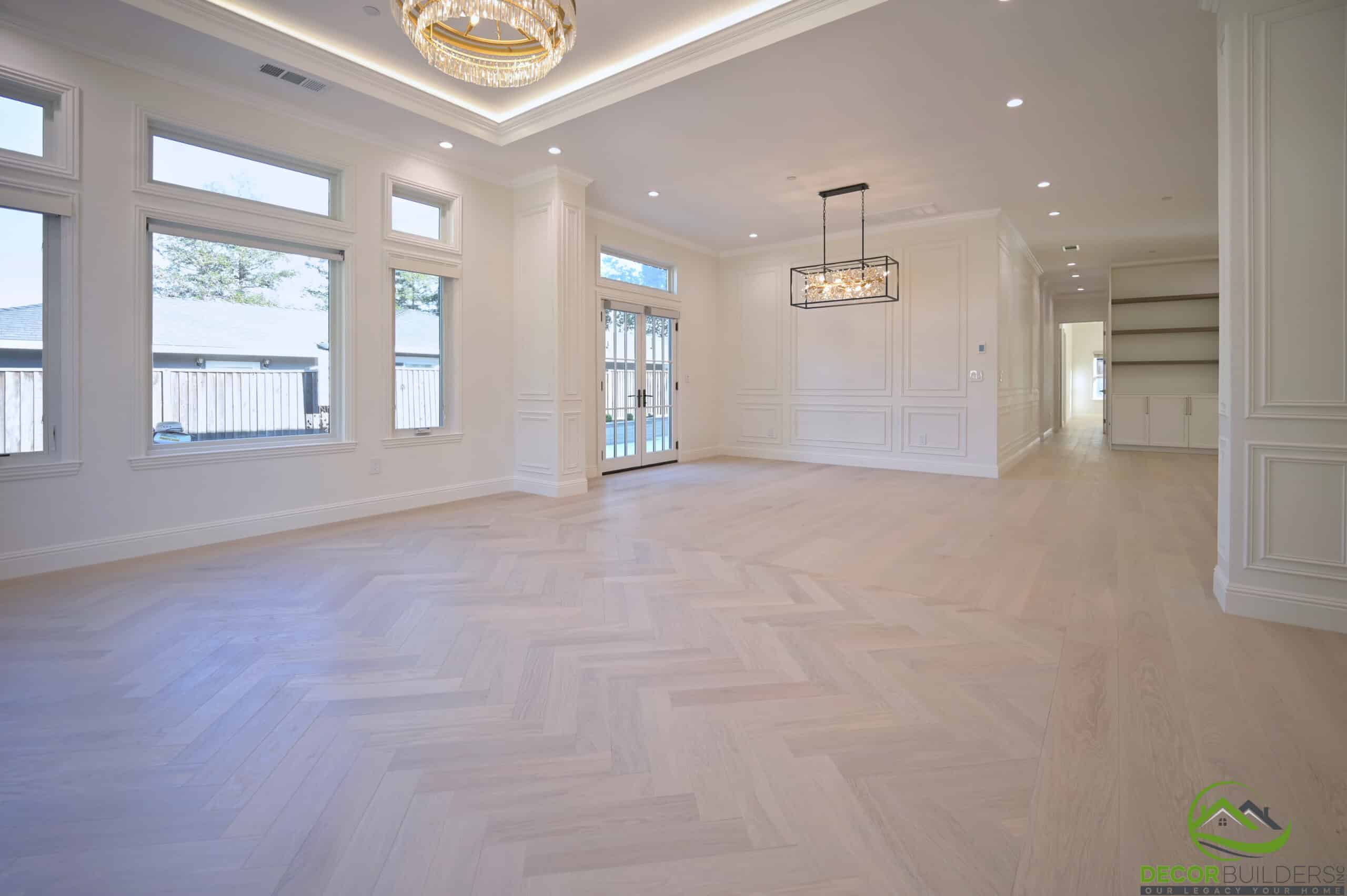 Open living and dining space with herringbone flooring, an example of custom home remodeling in Cupertino, CA