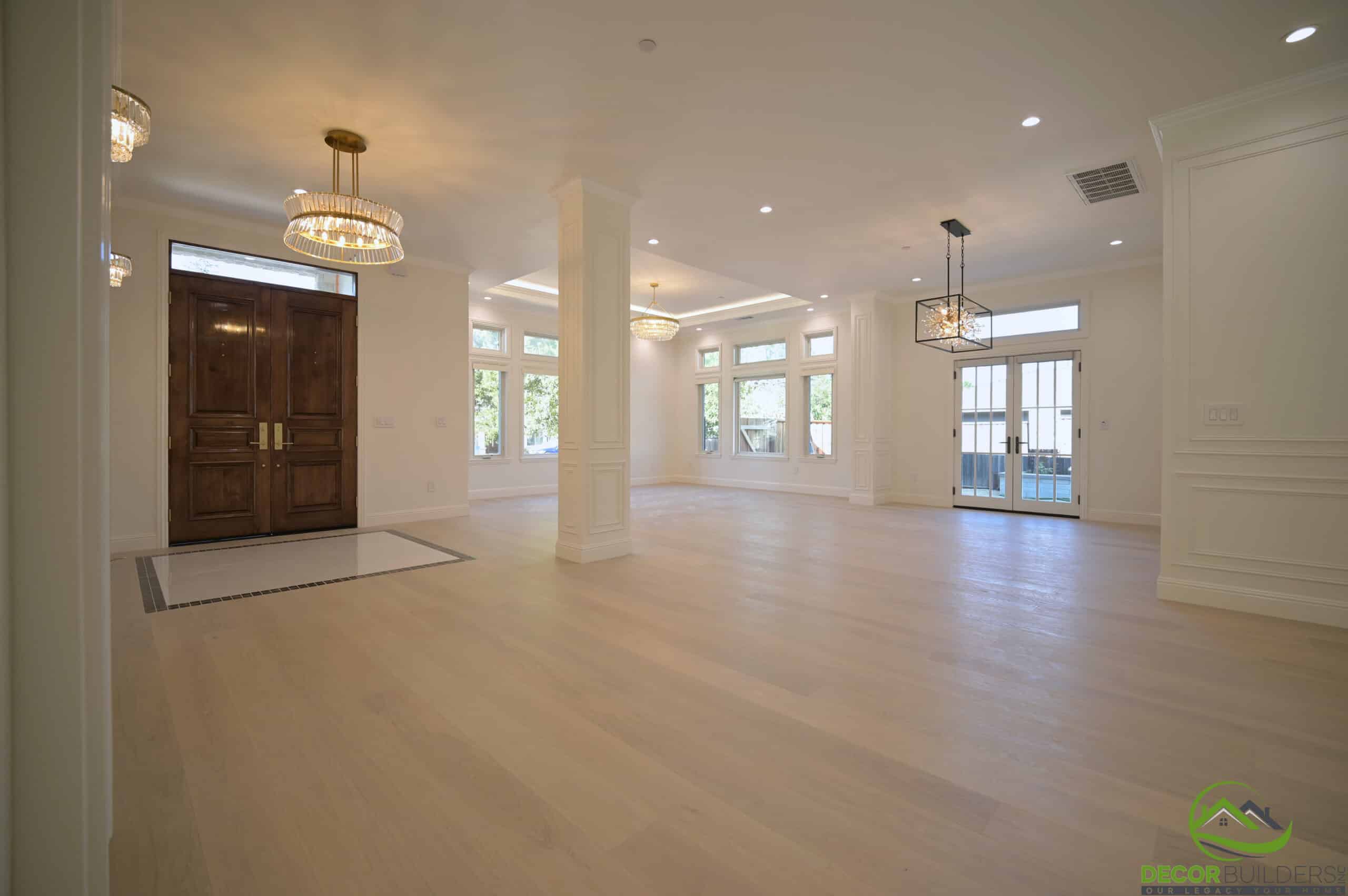 Open-concept great room with hardwood floors and wood double doors, completed during a custom home remodeling project in Cupertino, CA