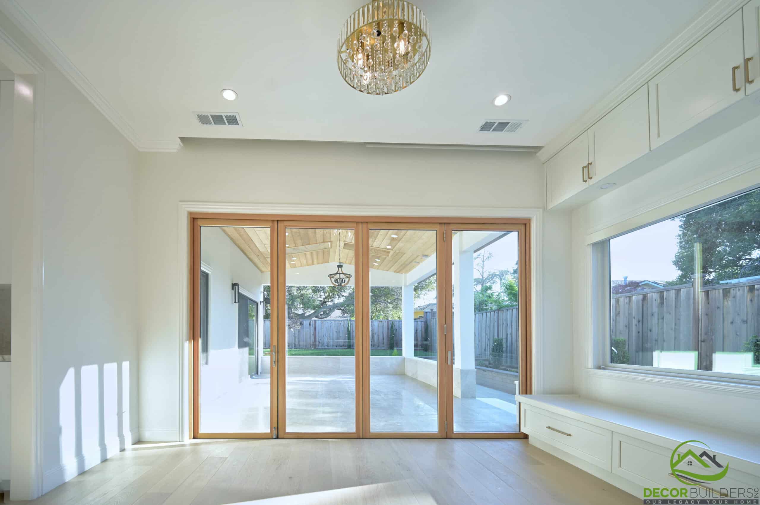 Family room with built-in window seat and sliding glass doors, part of a home remodeling project in Cupertino, CA
