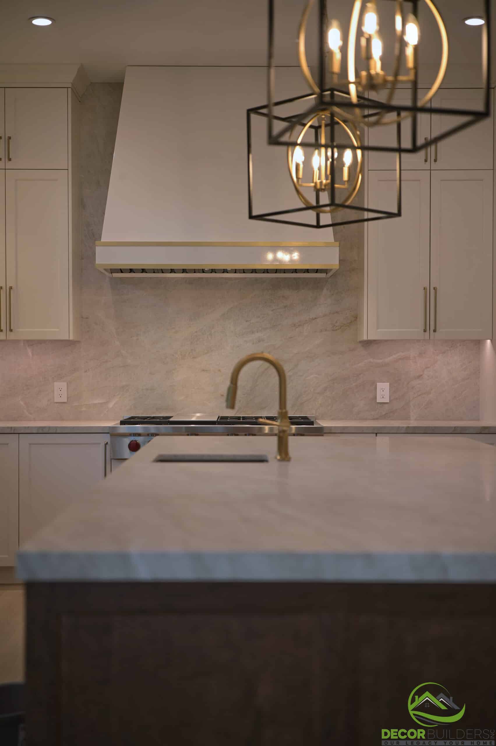 Kitchen range hood and cooktop with marble backsplash and brass fixtures, a custom kitchen remodeling detail in Cupertino, CA