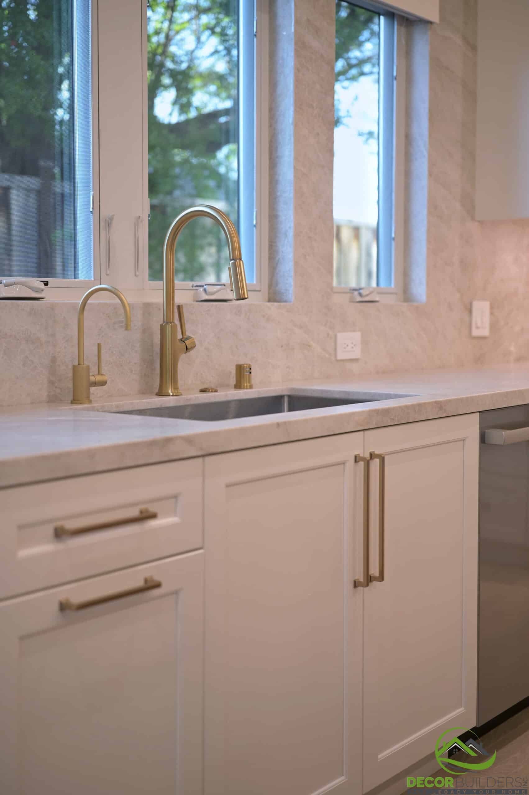 Kitchen sink with brass faucet and marble backsplash, a feature of a kitchen remodel in Cupertino, CA