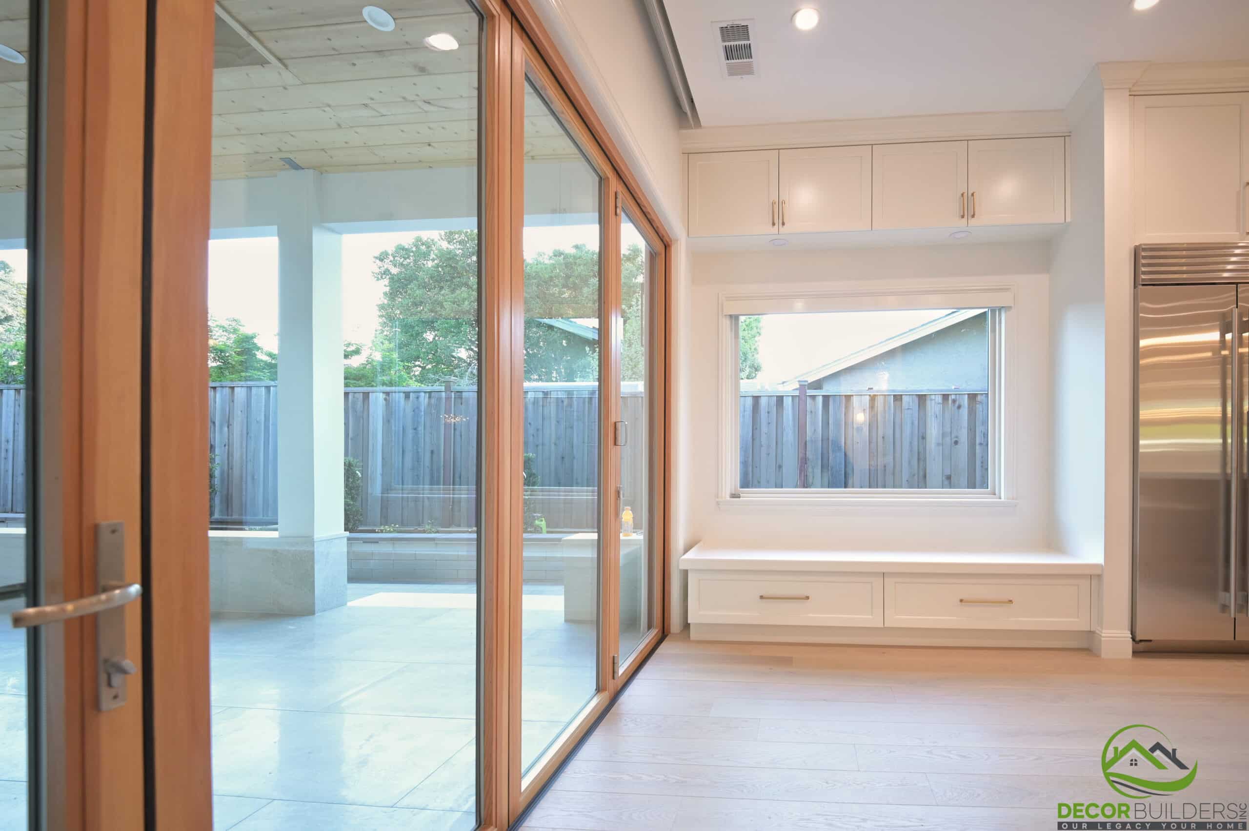 Open kitchen and living area with wood-framed glass doors, completed during a home renovation in Cupertino, CA