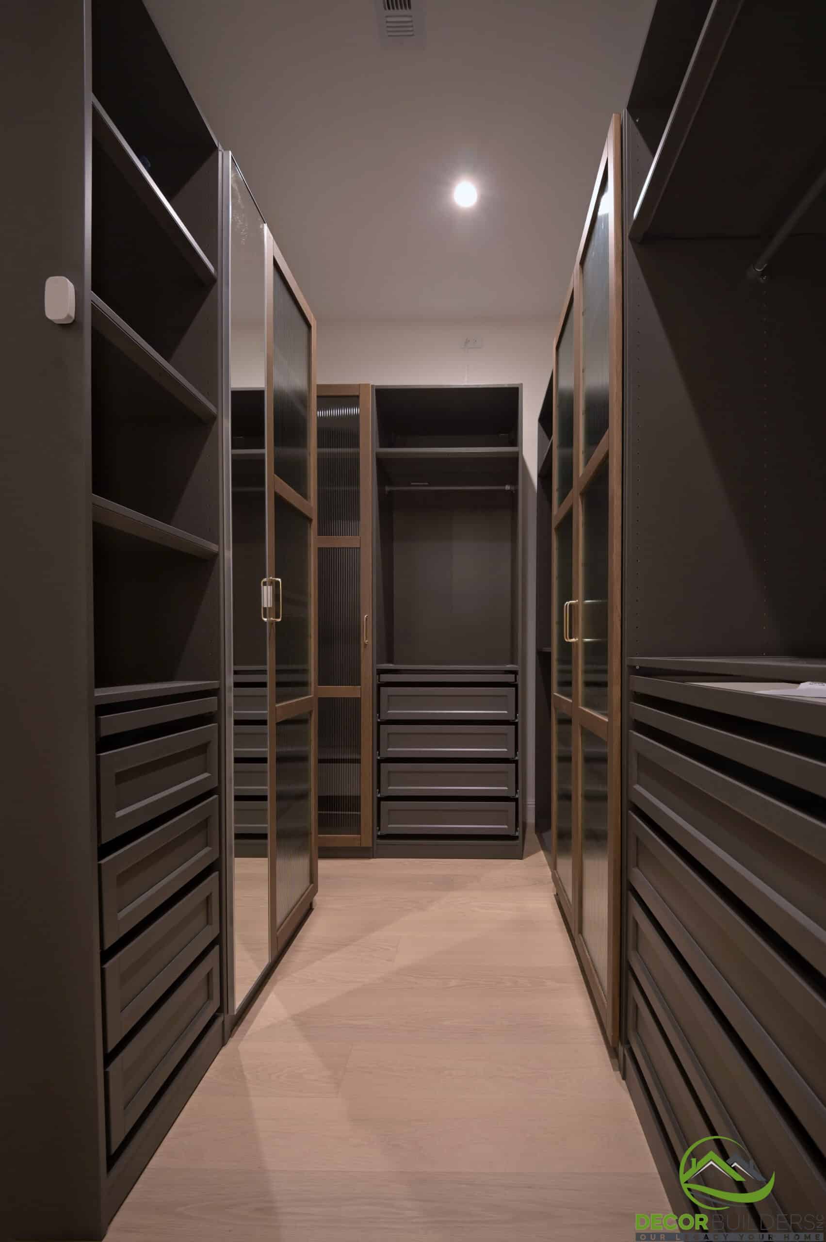 Custom walk-in closet with dark wood built-in cabinetry and shelving, part of a home remodeling project in Cupertino, CA
