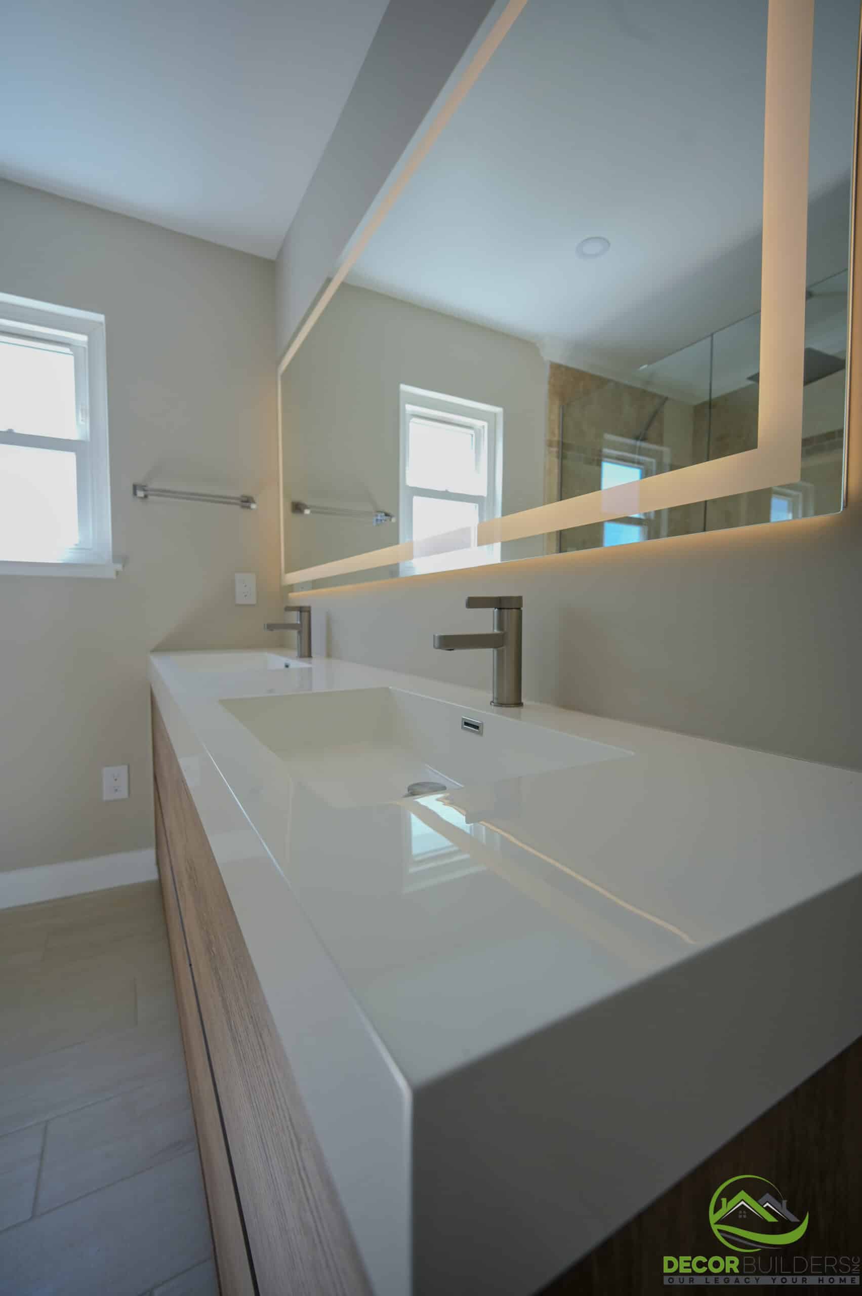 Bathroom renovation double trough sink with brushed nickel faucets, wood vanity, and backlit mirror, Foster City CA