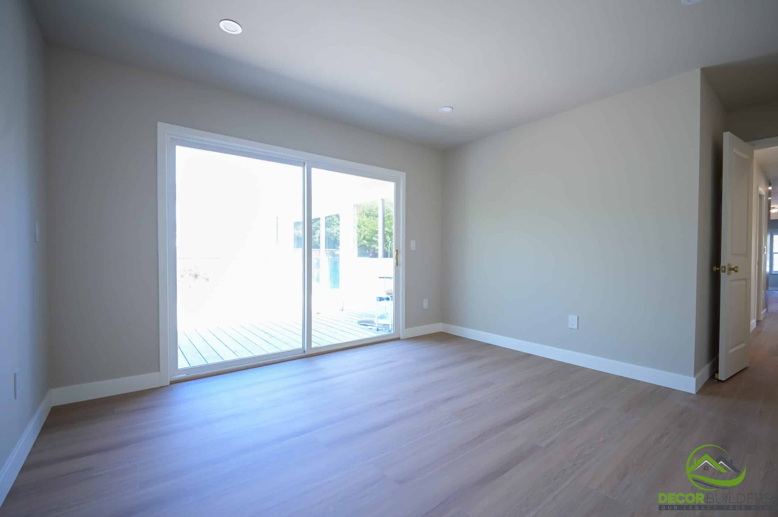Custom home remodeling bedroom with sliding glass door, hardwood floors, and recessed lighting, Foster City CA